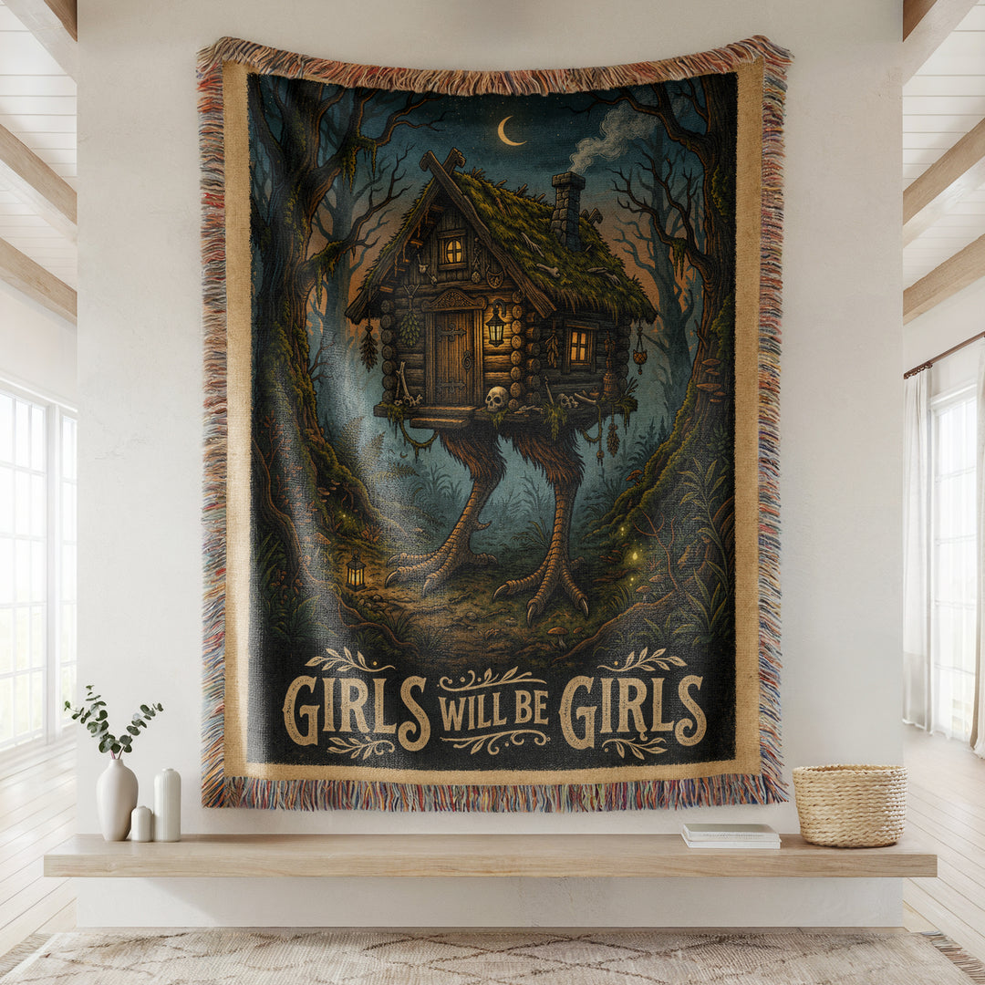 Tapestry with a Baba Yaga Hut cabin design and 'Girls Will Be Girls' text in a room setting.