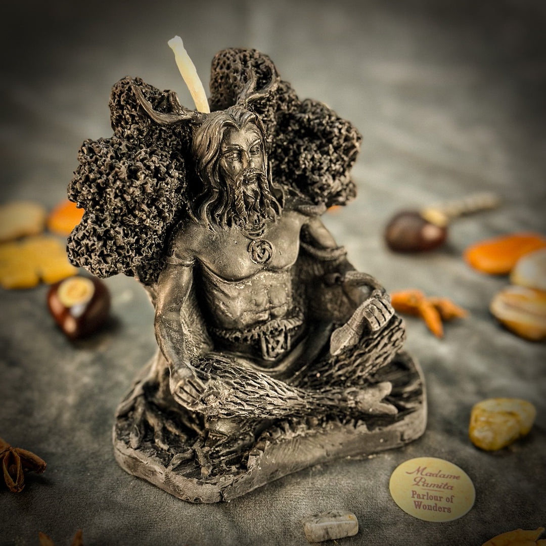 Beeswax Horned God Spell Candle with glowing wick, silvered figure detail, textured base.