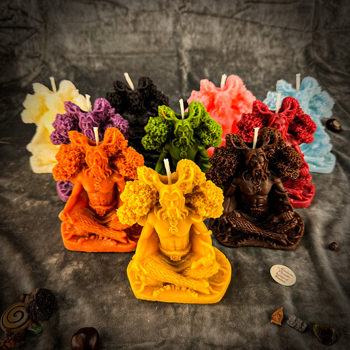 Beeswax Horned God Spell Candle with multicolored carved figure, flames, and wicks