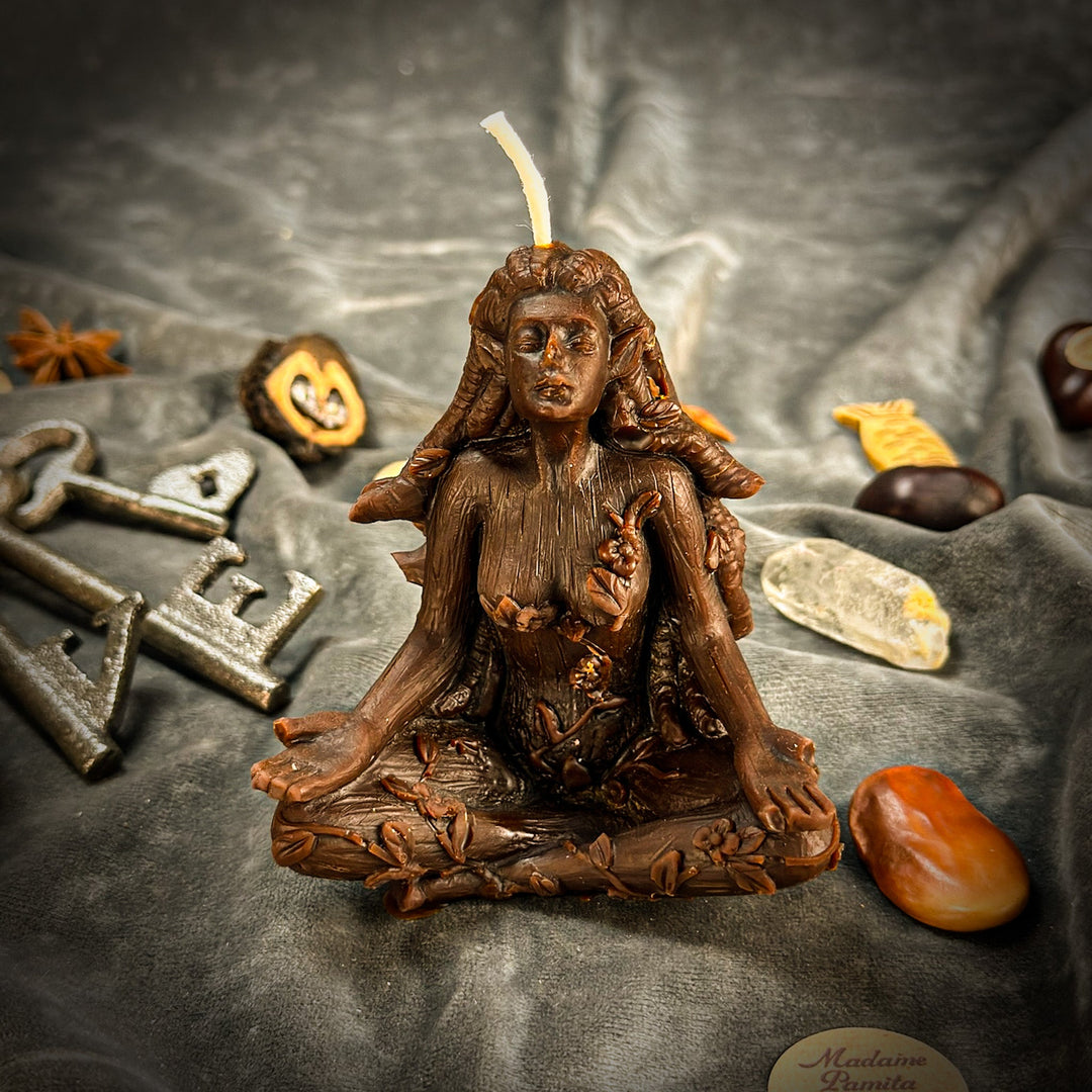 Beeswax Forest Fairy Spell Candle with lit wick atop bronze-toned figurine.