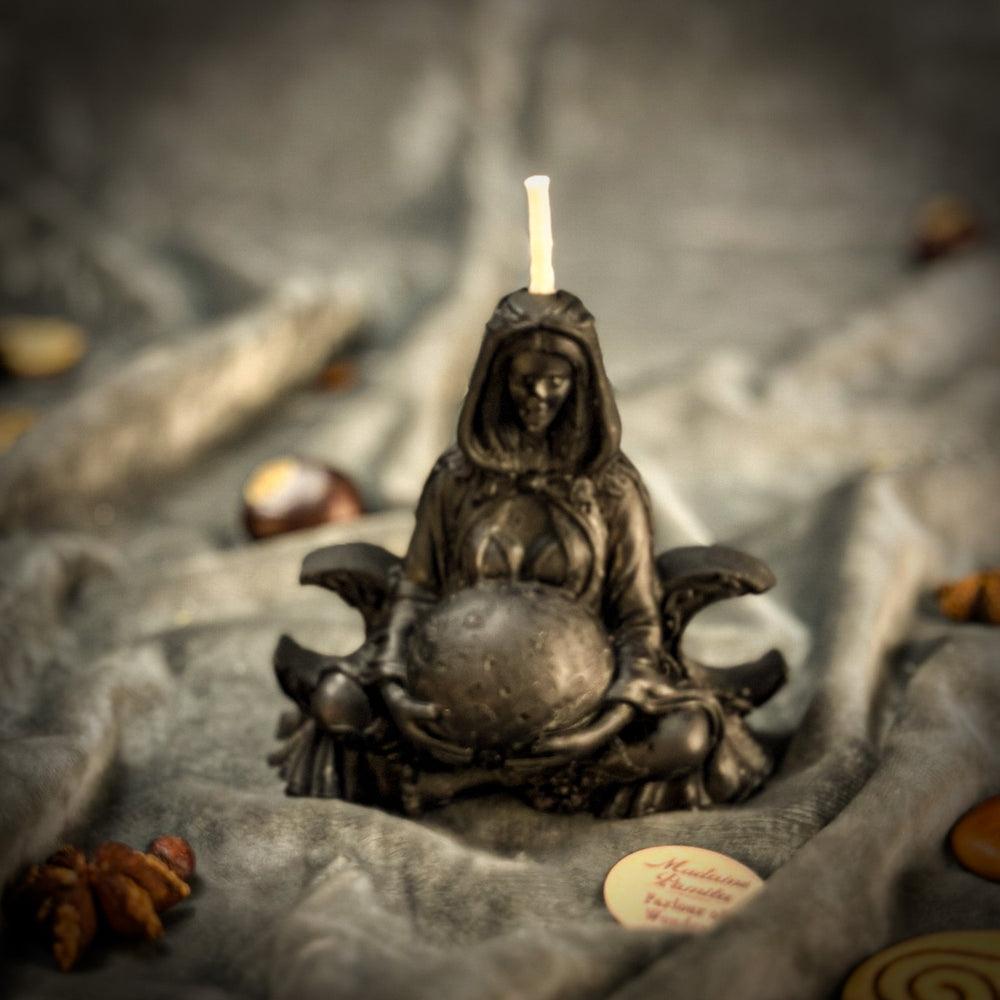 Beeswax Moon Goddess Spell Candle with lit flame atop dark sculpted base, close-up angle.