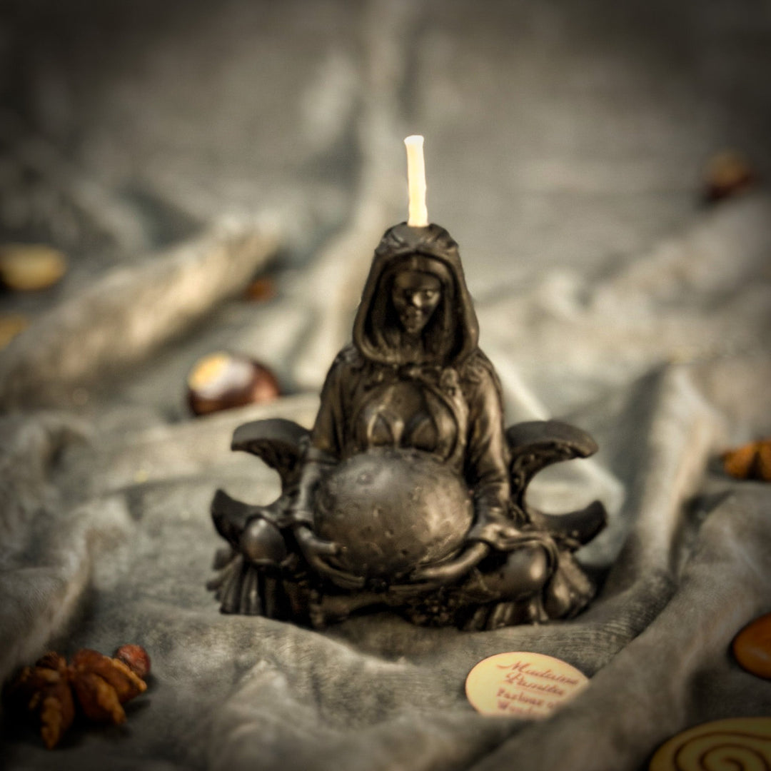 Beeswax Moon Goddess Spell Candle with lit flame atop dark sculpted base, close-up angle.