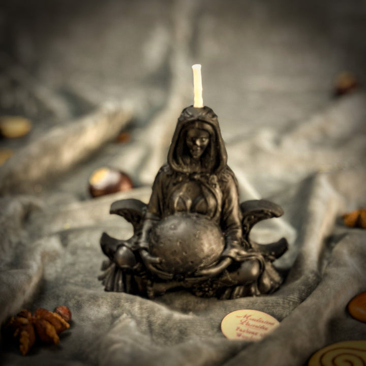 Beeswax Moon Goddess Spell Candle with lit flame atop dark sculpted base, close-up angle.