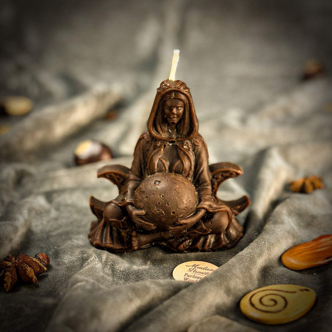 Beeswax Moon Goddess Spell Candle with carved figure, lit flame, warm bronze tones.