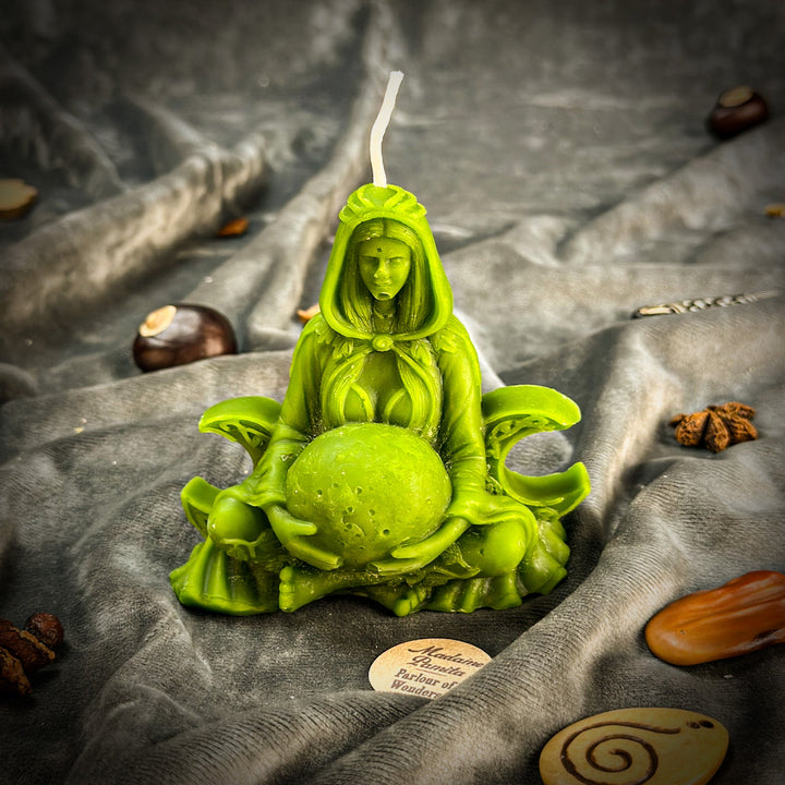 Beeswax Moon Goddess Spell Candle in bright green, lit flame, seated pose.
