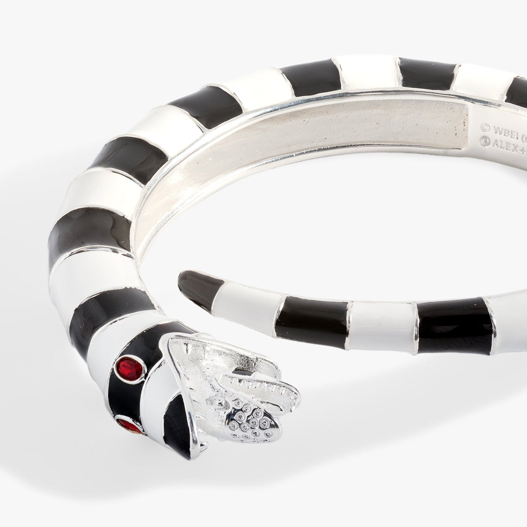 Silver bracelet with black and white striped pattern on a light gray background