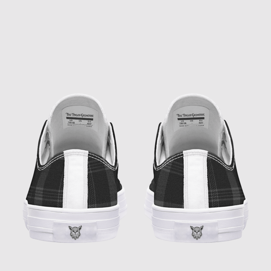 A pair of low-top slip-on sneakers shown from the back, featuring a black and white plaid pattern on the sides, a white vertical stripe, and a white rubber sole with a small owl head logo.