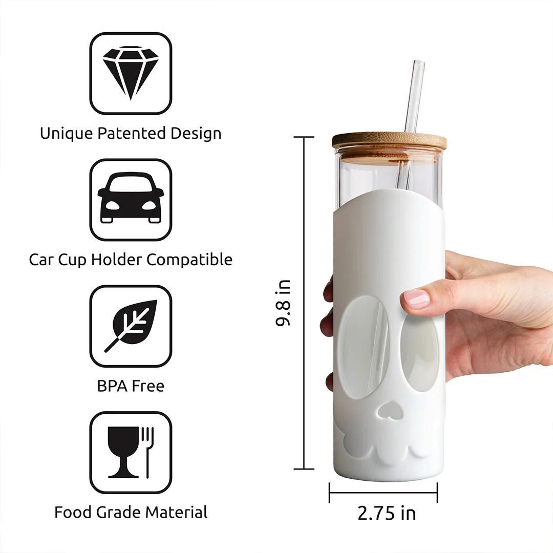 A hand holds a clear glass car cup with a white silicone holder, bamboo lid, and straw on a white background. Black icons and text on the left highlight features: unique patented design, car cup holder compatibility, BPA free, and food grade material.