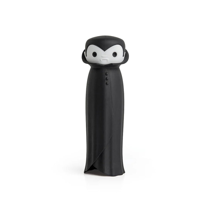 A black and white stylized garlic press resembling a vampire with a long black robe and small white face details, photographed on a clean white background.