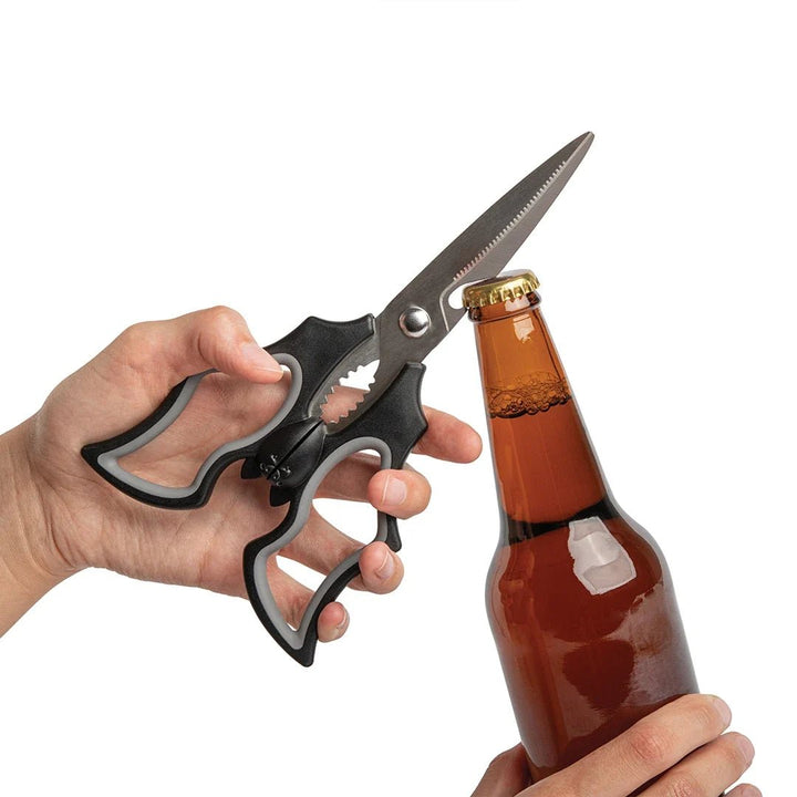 Bat scissors being used as a bottle opener on a white background