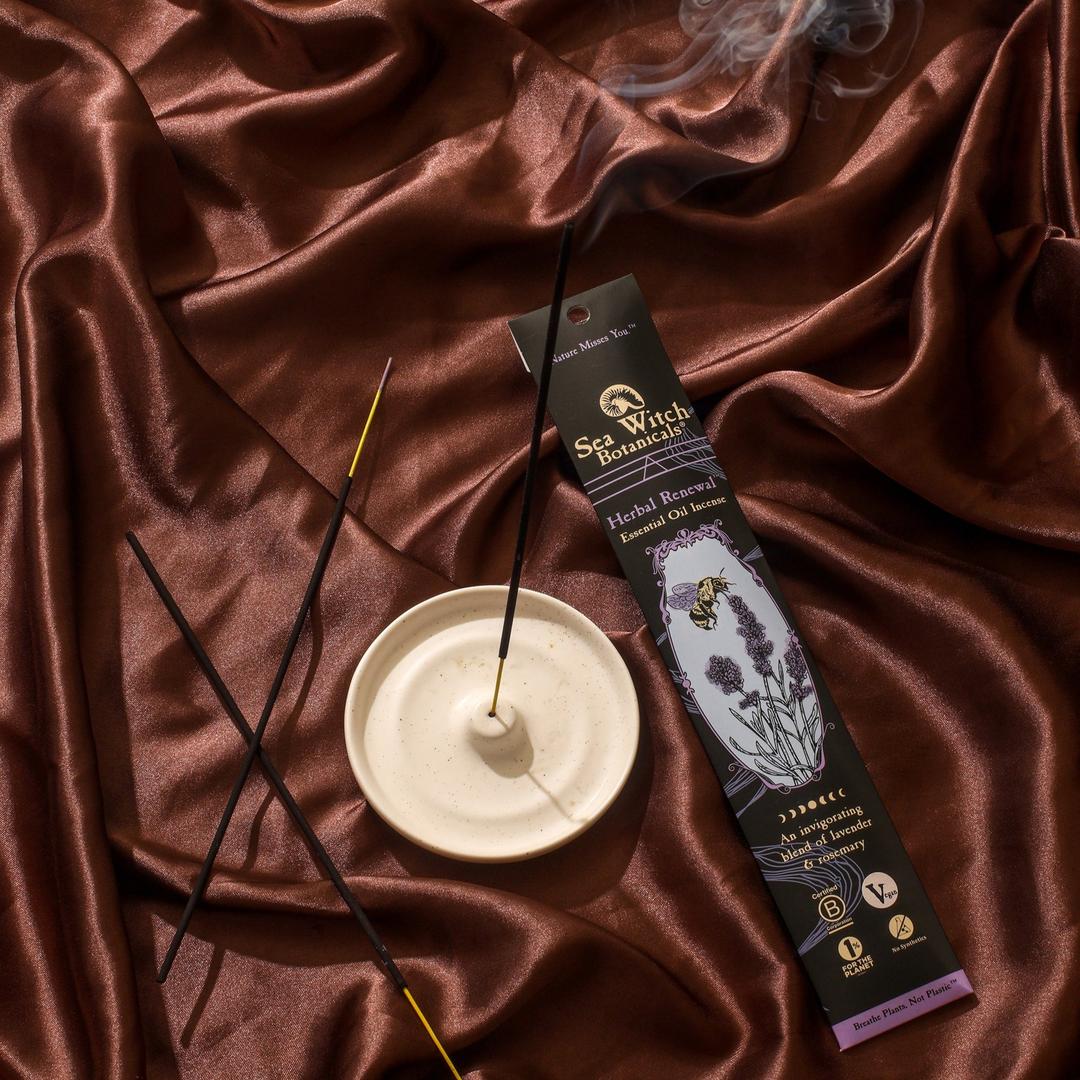 Incense gift set with black sticks, lavender box, and white burner dish.