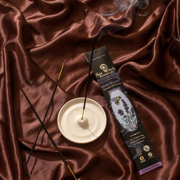 Incense gift set with black sticks, lavender box, and white burner dish.