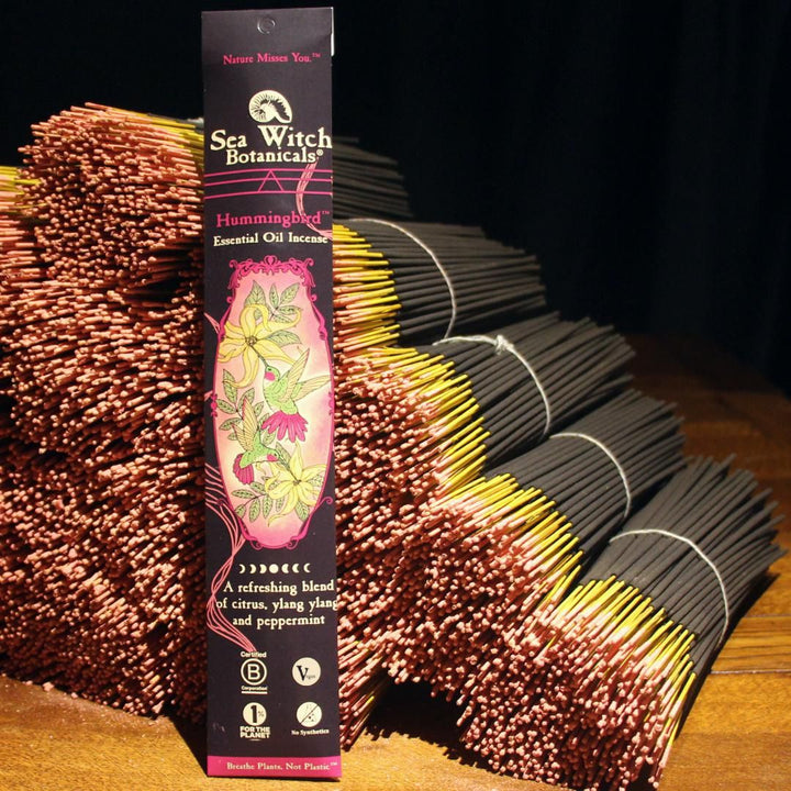Hummingbird Premium Incense box beside fanned brown incense sticks with yellow tips.