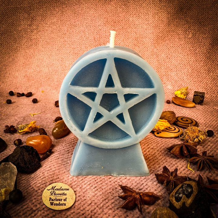 Beeswax Pentacle of Protection Spell Candle with blue pentagram cutout, wick up, on textured fabric.