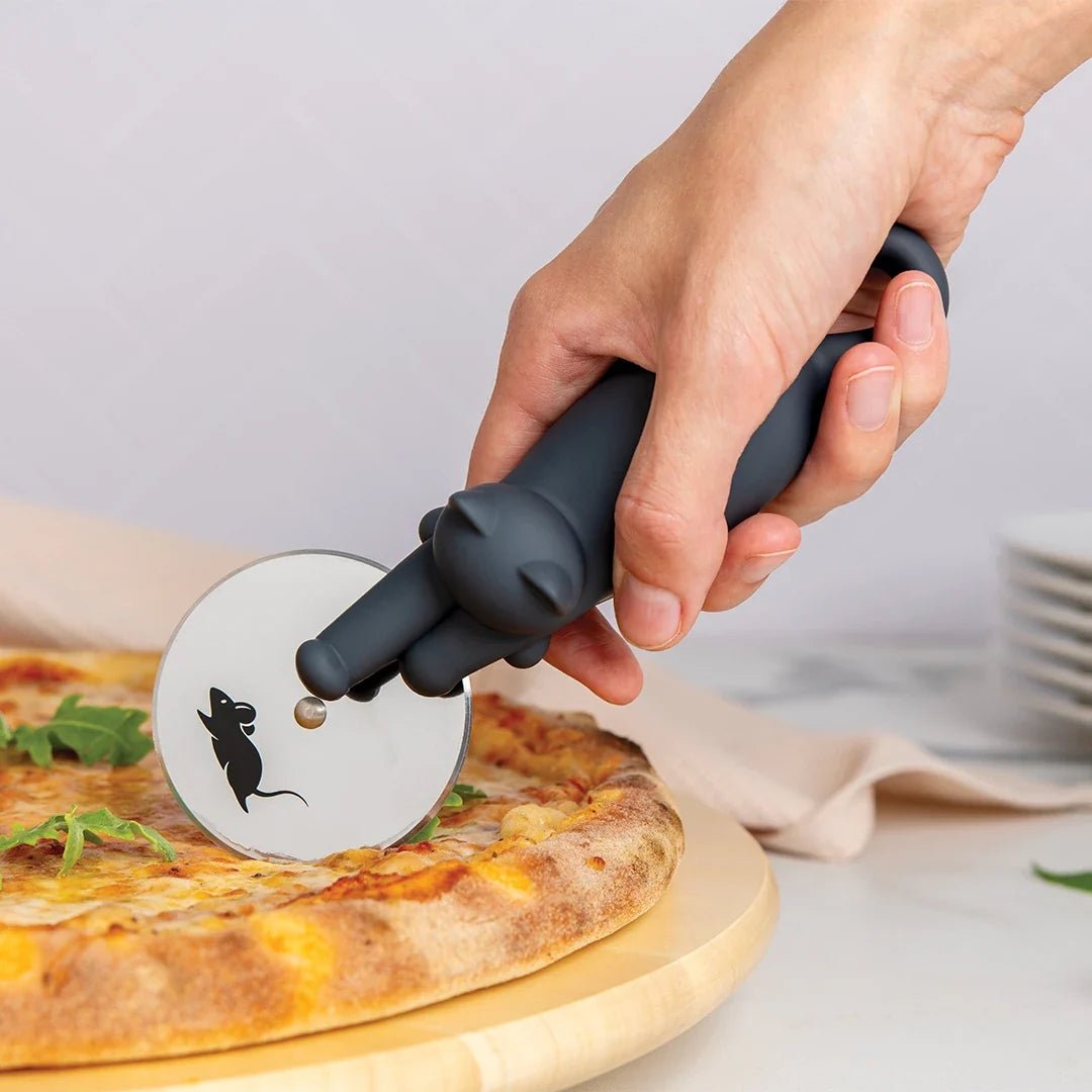 Person using a pizza cutter with a black cat design on a pizza