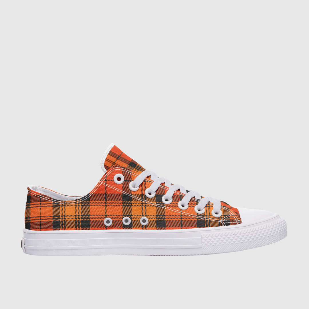 A low-top canvas sneaker featuring a vibrant orange and black tartan plaid pattern on the upper, white laces, and a white rubber sole, shown against a light gray background.