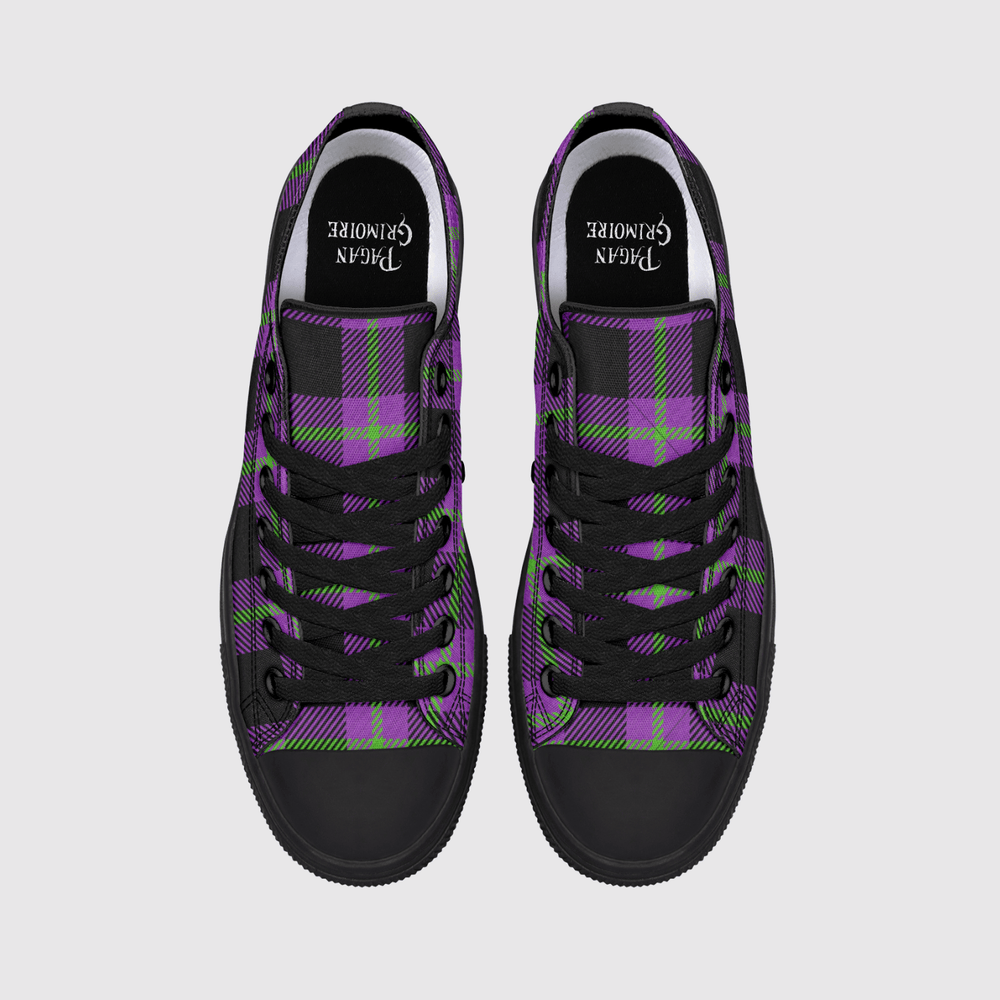 A pair of low-top canvas sneakers shown from a top-down view on a light gray background. The shoes feature a purple and black tartan plaid pattern with lime green accents, black laces, and black rubber toe caps.