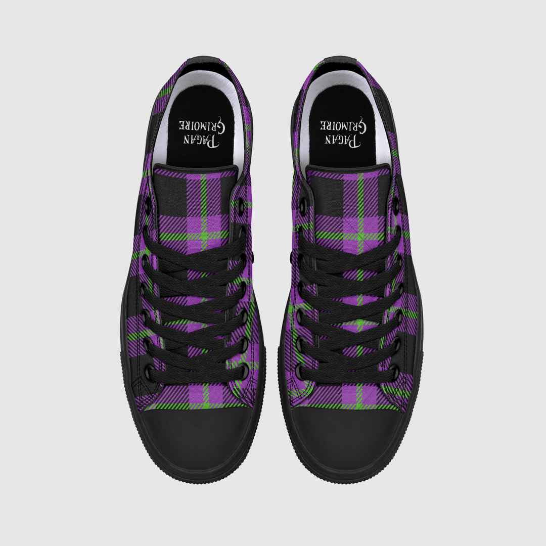 A pair of low-top canvas sneakers shown from a top-down view on a light gray background. The shoes feature a purple and black tartan plaid pattern with lime green accents, black laces, and black rubber toe caps.