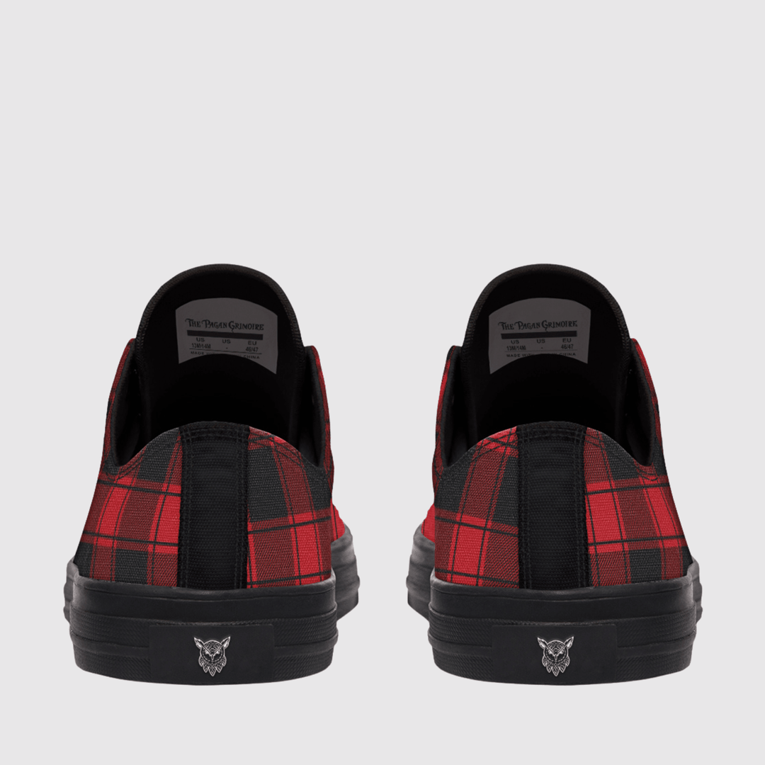 A pair of low-top sneakers shown from the back, featuring a red and black plaid pattern on the sides, solid black fabric on the heel tab, and a black sole with a small silver logo.