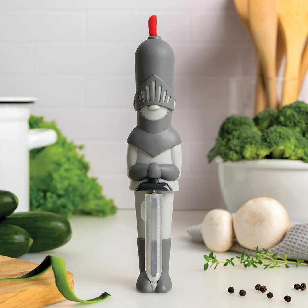 Vegetable peeler shaped like a knight on a kitchen counter with vegetables in the background