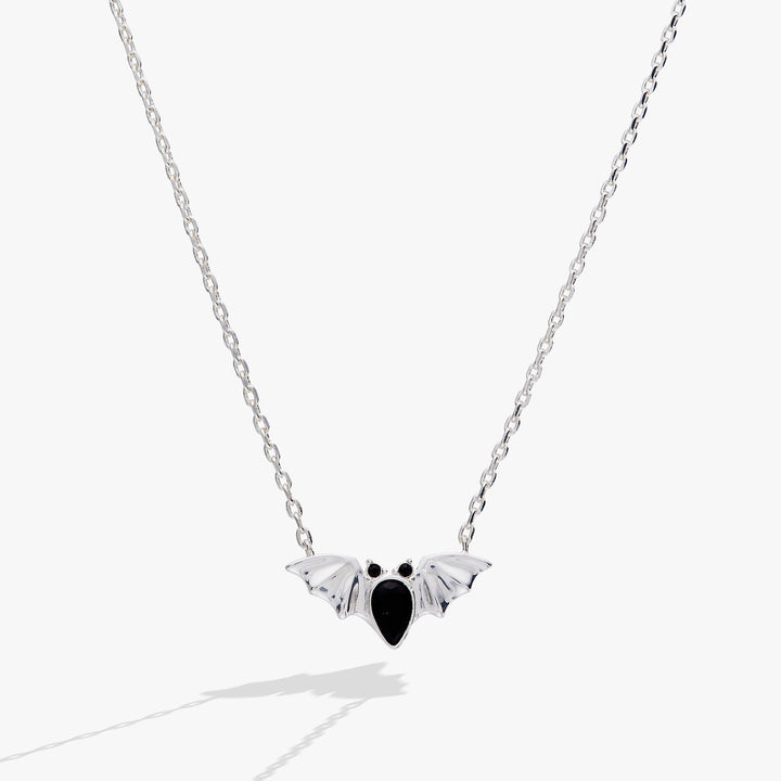 Silver necklace with a bat-shaped pendant on a white background