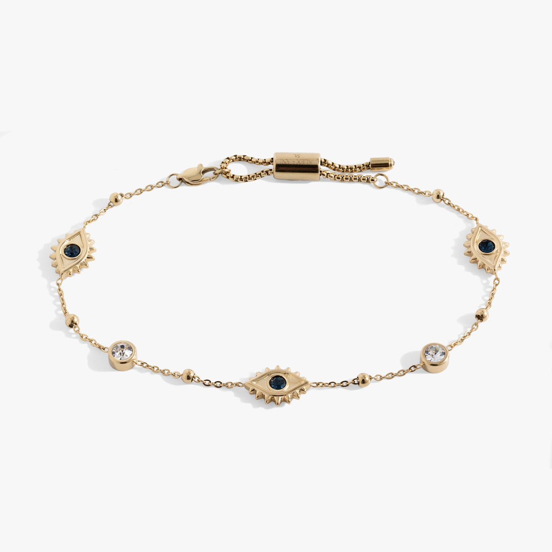 A gold chain bracelet featuring three sunburst evil eye motifs with black centers, one larger central eye, and three smaller sunburst eyes spaced along the chain, with a lobster clasp closure at the top.