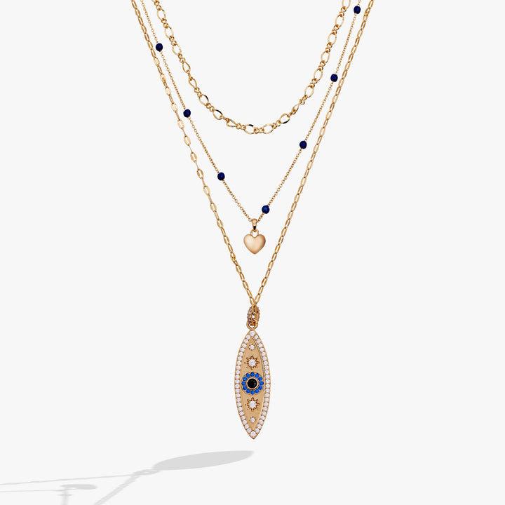 Layered gold necklaces with blue gemstone pendants on a white background