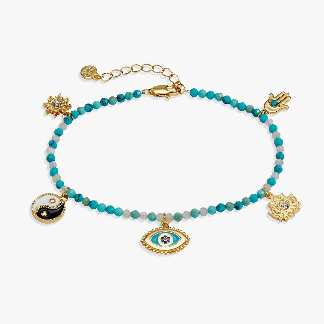 A gold-tone beaded bracelet with turquoise blue beads, featuring multiple charms including a Hamsa hand, an evil eye, a lotus flower, a yin-yang symbol, and a sun, displayed on a clean white background.