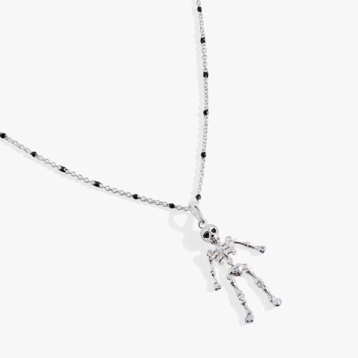 Silver skeleton pendant necklace on a white background